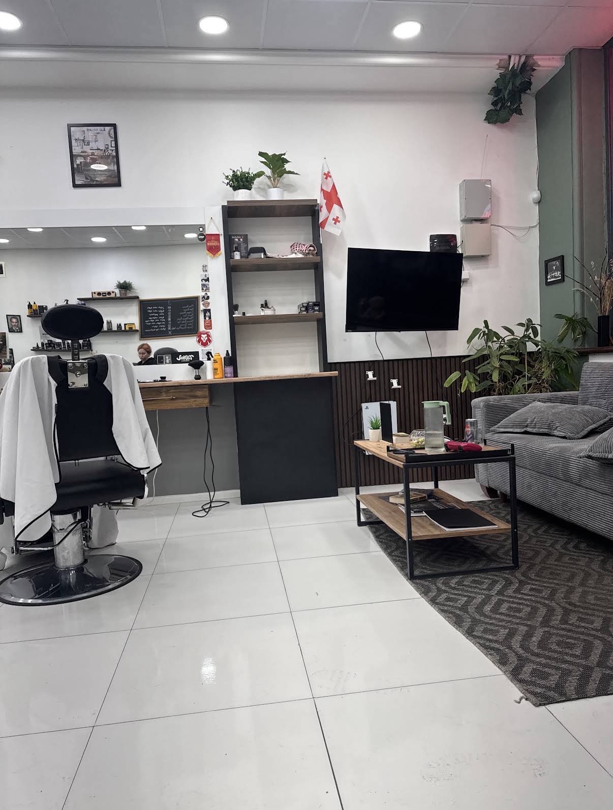 Lounge area with sofa, TV and PlayStation for waiting clients
